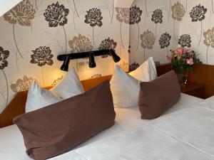 莱比锡柏林酒店的一间卧室配有带白色床单和枕头的床。