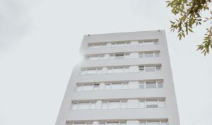 布兰卡港Corrientes Premium con desayuno的阴天下高大的白色建筑