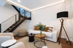 塞维利亚La Sillería de Triana by Magno Apartments的客厅设有白色沙发和楼梯。