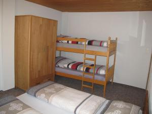 GarzHoliday Home Kaiser by Interhome的客房设有两张双层床和木制橱柜。