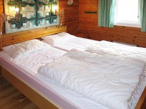 HolsenChalet Fjellbris - FJS106 by Interhome的木制客房内的一张大白色床