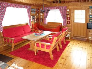 HolsenChalet Fjellbris - FJS106 by Interhome的客厅配有红色的沙发和桌子