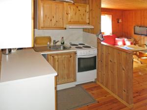 凯于庞厄尔Holiday Home Turken - FJS767 by Interhome的厨房配有木制橱柜和白色炉灶烤箱。