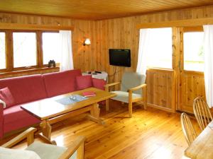 凯于庞厄尔Holiday Home Turken - FJS767 by Interhome的客厅配有红色的沙发和桌子