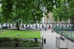 伦敦欧洲人酒店的公园里有人坐在大楼前的草地上