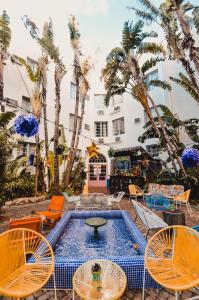 迈阿密海滩迈阿密写意酒店的一个带椅子的庭院、一个游泳池和棕榈树