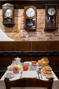 威尼斯埃尔加泽蒂诺酒店的桌上摆着早餐食品和墙上的时钟