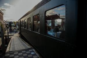 WilderenGasthof De Statie的黑色火车,在平台上装有窗户