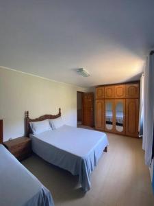 新弗里堡Casa Espetacular no Centro da Serra的一间卧室设有两张床和木制橱柜。