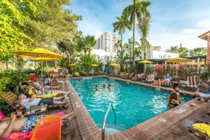 迈阿密海滩迈阿密写意酒店的一群人坐在度假村的游泳池周围