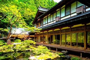 高野山高野山 宿坊 龍泉院 -Koyasan Shukubo Ryusenin-的花园前带池塘的建筑