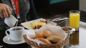 利马Hotel Diamond Lima的桌上摆着一篮早餐食品和一杯咖啡