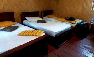 锡吉里亚Tree house Hostel Sigiriya的一间房间里三张床的组合