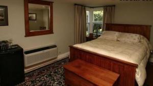 帕里桑德海边宾馆的一间卧室配有一张床、镜子和窗户