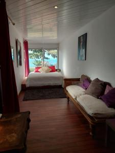 Saint-PierreVilla des Galets的一间卧室配有一张床、一张沙发和一个窗口