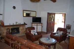 卡斯特里洛德罗波尔瓦扎勒斯洛斯珀尔瓦萨雷斯度假屋的客厅配有皮革家具和壁炉