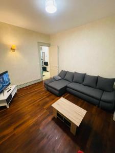 圣克洛德Appartement proche de la ville et du parc du Truchet的带沙发和咖啡桌的客厅