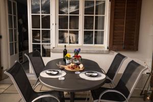 GsteigChalet Spitzhorn - Your Peak Getaway - Private Terrasse & gratis Parkplatz的黑色桌子和椅子,配酒杯和鲜花