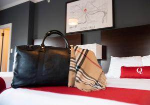 格伦斯福尔斯昆斯伯里酒店的睡在床上的黑钱包