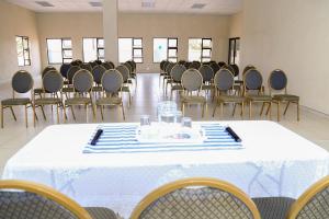 MoletlaneLempitse Lodge的一间摆放着椅子和一张桌子的房间,配有白色的桌布