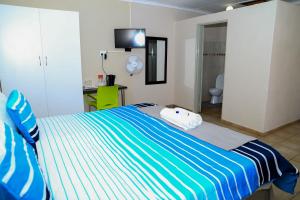 MoletlaneLempitse Lodge的卧室配有蓝色和白色条纹床