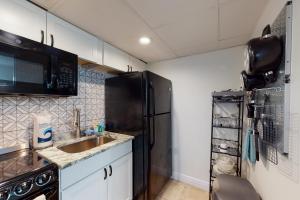 巴拿马城海滩Ambassador C5的厨房配有水槽和黑冰箱。
