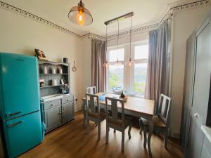 泰纳布鲁厄赫Upper Villa, Tighnabruiach, Argyll & Bute的厨房配有木桌和蓝色冰箱。