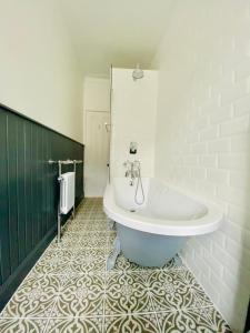 泰纳布鲁厄赫Upper Villa, Tighnabruiach, Argyll & Bute的带浴缸的浴室和瓷砖地板。
