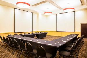 萨卡特卡斯萨卡特卡斯节日酒店的一间会议室,配有长桌子和椅子
