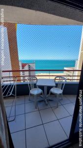 福塔莱萨Porto de Iracema Vista Mar的海景阳台上的桌椅