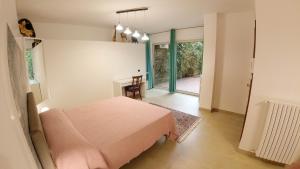 恩纳Il Piccolo Hotel的卧室配有粉红色的床和桌子