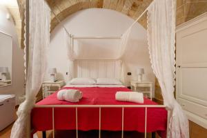 科佩尔蒂诺B&B La Ulia的一间卧室配有红色的床和两条白色毛巾