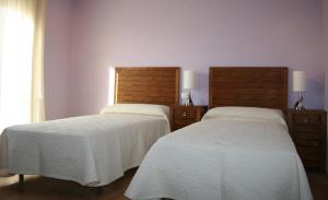 CerolleraHostal La Cerollera的两张睡床彼此相邻,位于一个房间里