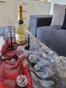 梅杜林Sea View Medulin Apartment - Orijeta的桌子上放有一瓶葡萄酒和两杯酒