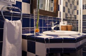 Nohales洛马乡村酒店的蓝色和白色的浴室设有水槽和镜子