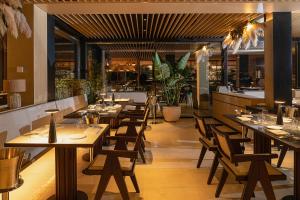 巴科利Dimora dei Lari的一间带木桌椅的餐厅和一间酒吧