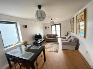 斯旺西Lovely 2-Bedrooms Apartment Step to The Beach的客厅配有桌子和沙发