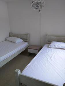 里考尔特Apartamento en Ricaurte的卧室设有两张单人床和风扇