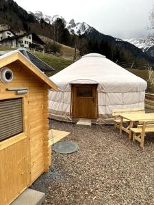 特里森贝格Jurte beim Lama- & Alpakahof Triesenberg的帐篷配有野餐桌和长凳