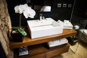 莫雷利亚卡萨马德罗精品酒店的浴室设有水槽,在柜台上放着花朵