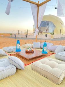 BadīyahStarry Domes Desert Camp的沙漠桌子上的一组枕头