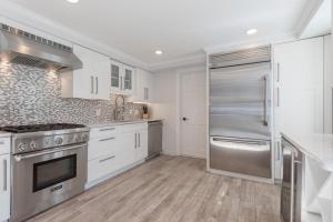 楠塔基特45A Pleasant St的厨房配有白色橱柜和不锈钢冰箱