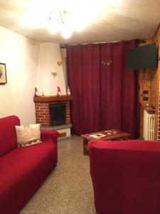 蓬泰迪莱尼奥Appartamento Castellaccio的客厅设有红色的沙发和壁炉