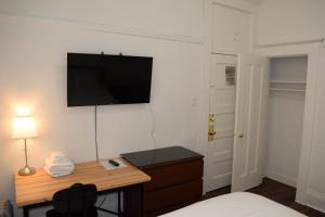 旧金山Hotel Ikon的卧室配有书桌和墙上的电视。