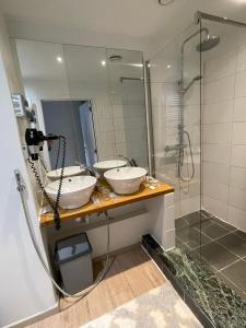 克诺克－海斯特Hotel De Backer的一间带两个盥洗盆和淋浴的浴室