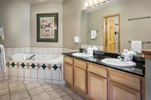 布雷肯里奇Grand Timber Lodge的浴室配有两个盥洗盆和浴缸。