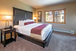 布雷肯里奇Grand Timber Lodge的一间卧室设有一张大床和两个窗户。