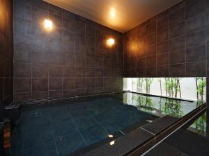 东京新宿歌舞伎町超级酒店的一个带瓷砖墙的房间的游泳池