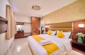 吉隆坡V Hotel Pudu Kuala Lumpur的一间卧室配有一张带黄色和白色枕头的大床