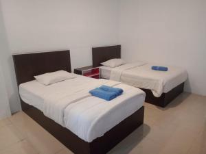 马塔兰安雅宾馆的客房内的两张床和蓝色枕头